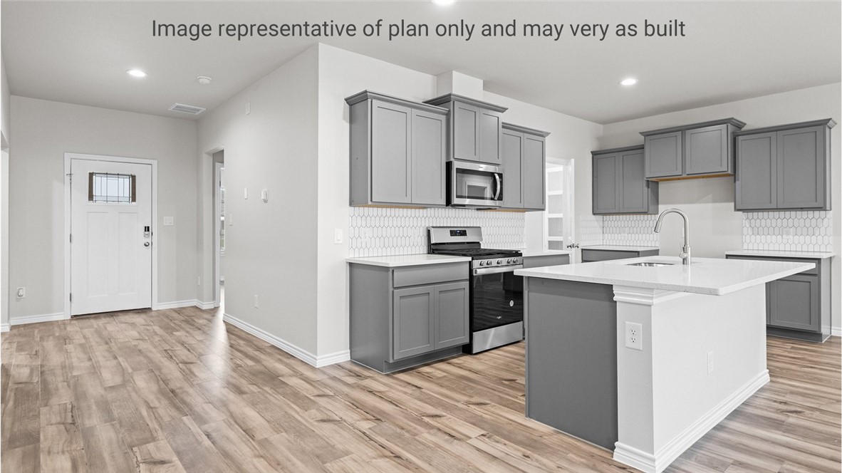 1409 Irigoyen Street Corpus Christi, TX 78415 - Photo 10 of 38 a kitchen with cabinets and wooden floor