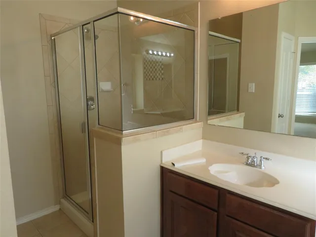 a bathroom with a shower sink and mirror