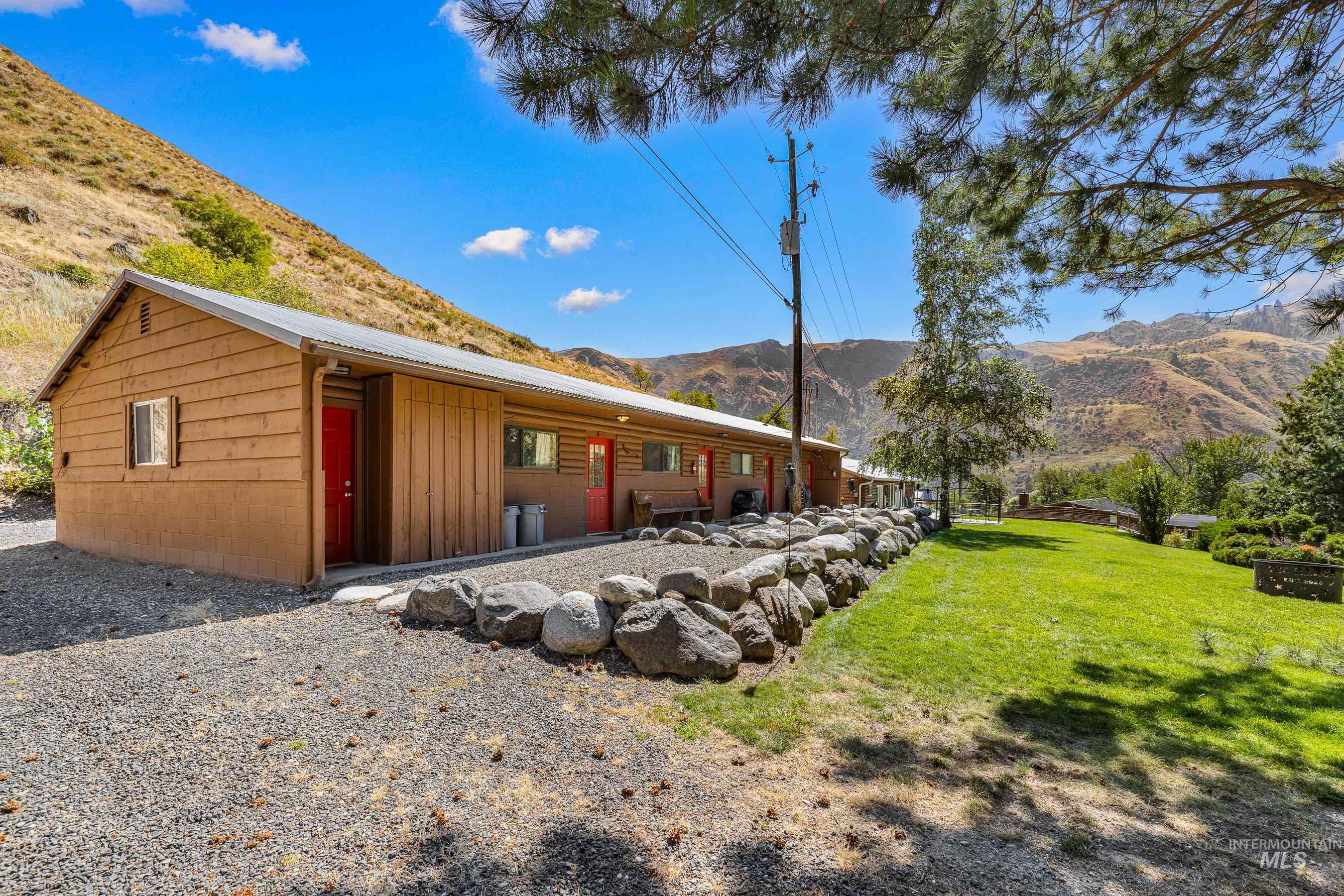 Back of property featuring a mountain view, a metal roof, a yard, and board and batten siding