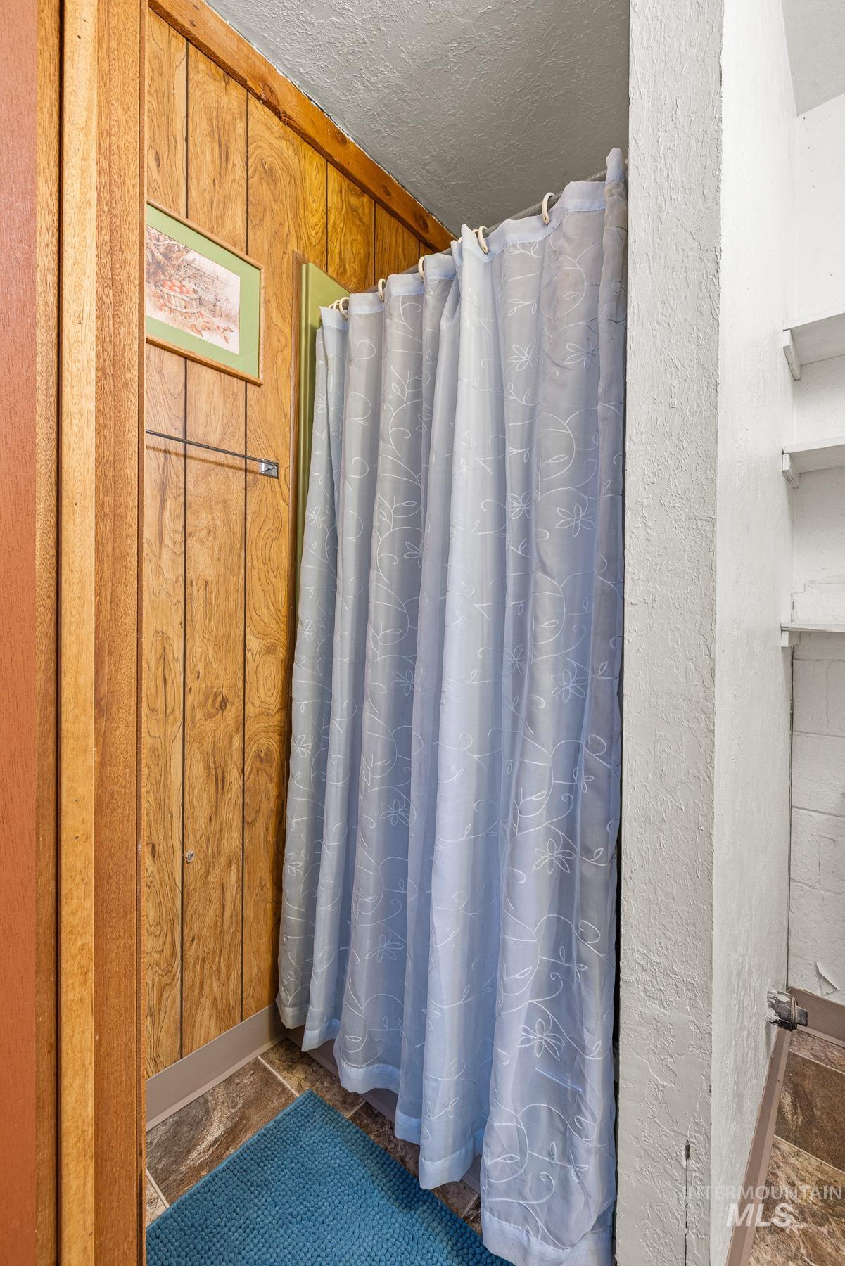 192 East Shingle Creek Road Riggins, ID 83549 - Photo 33 of 50 Full bath with a shower with curtain, a textured ceiling, a textured wall, and dark stone finish flooring