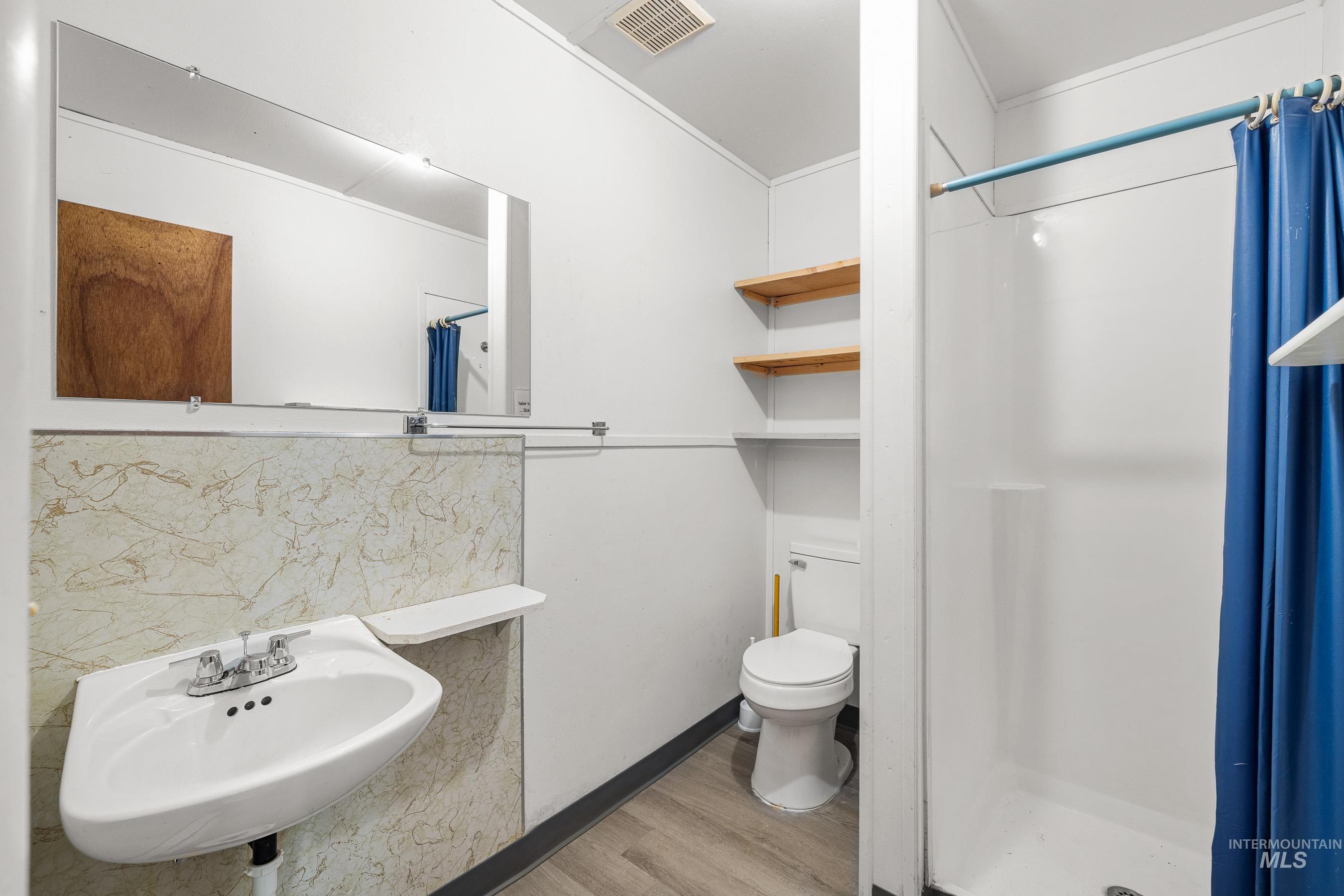 192 East Shingle Creek Road Riggins, ID 83549 - Photo 46 of 50 Bathroom featuring a shower stall, light wood finished floors, and decorative backsplash