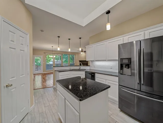 a kitchen with a refrigerator a sink and cabinets