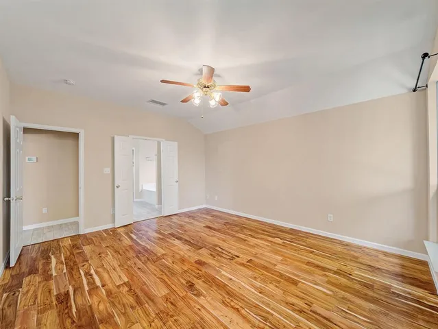 a bedroom with a bed and a chandelier fan