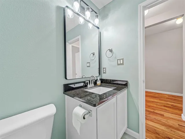 a bathroom with a granite countertop sink and a mirror