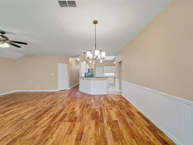 a view of a room with wooden floor and chandelier