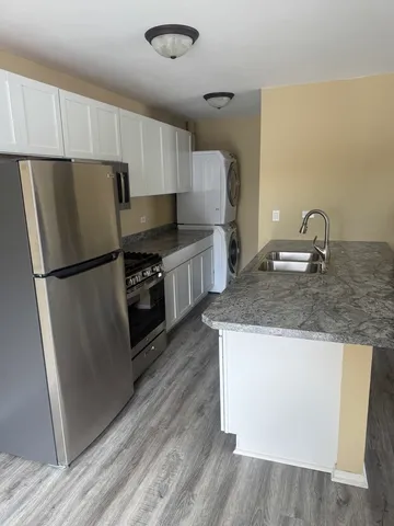 a kitchen with granite countertop a refrigerator and a sink