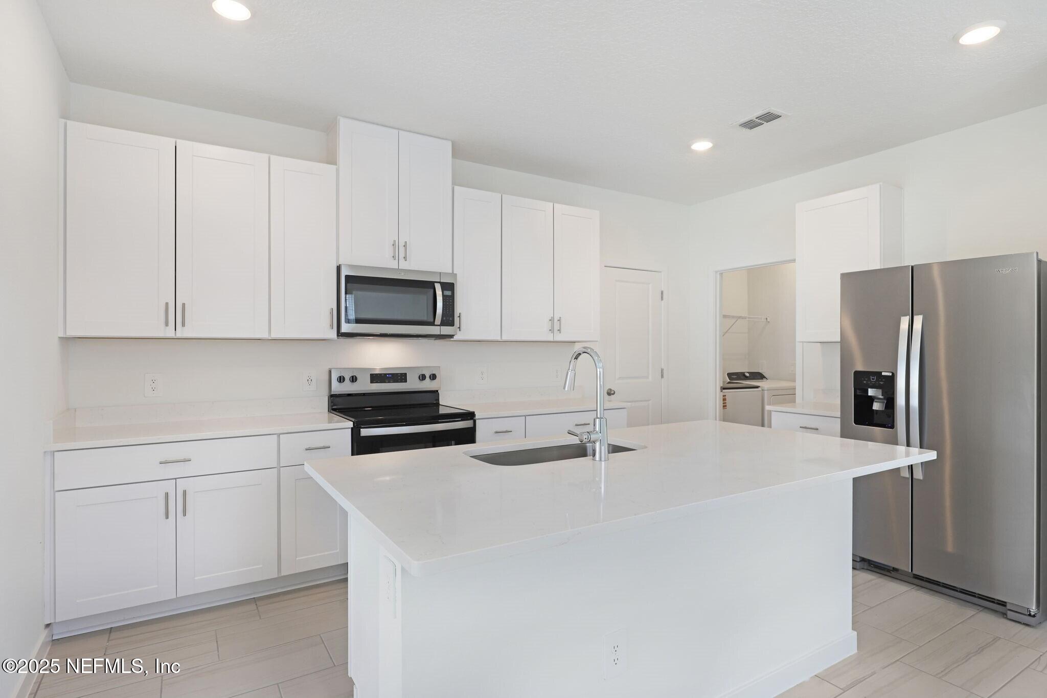 9638 Cypress Mdws Road Jacksonville, FL 32219 - Photo 4 of 35 a kitchen with stainless steel appliances a refrigerator a stove a sink and white cabinets