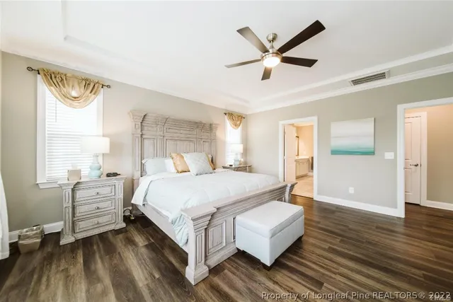 a bedroom with a large bed a flat tv screen and dresser