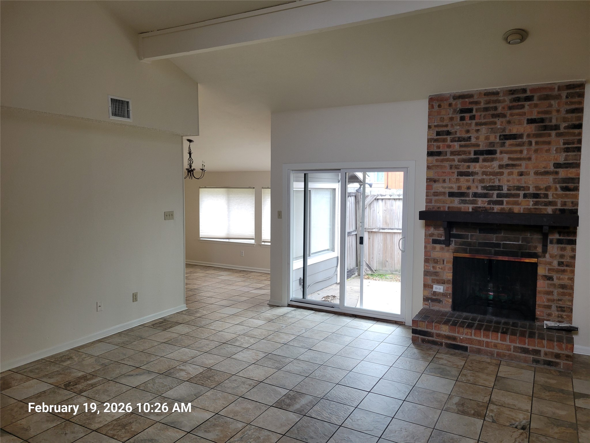 7266 Coronado Circle Austin, TX 78752 - Photo 2 of 11 Unfurnished living room featuring a brick fireplace and lofted ceiling