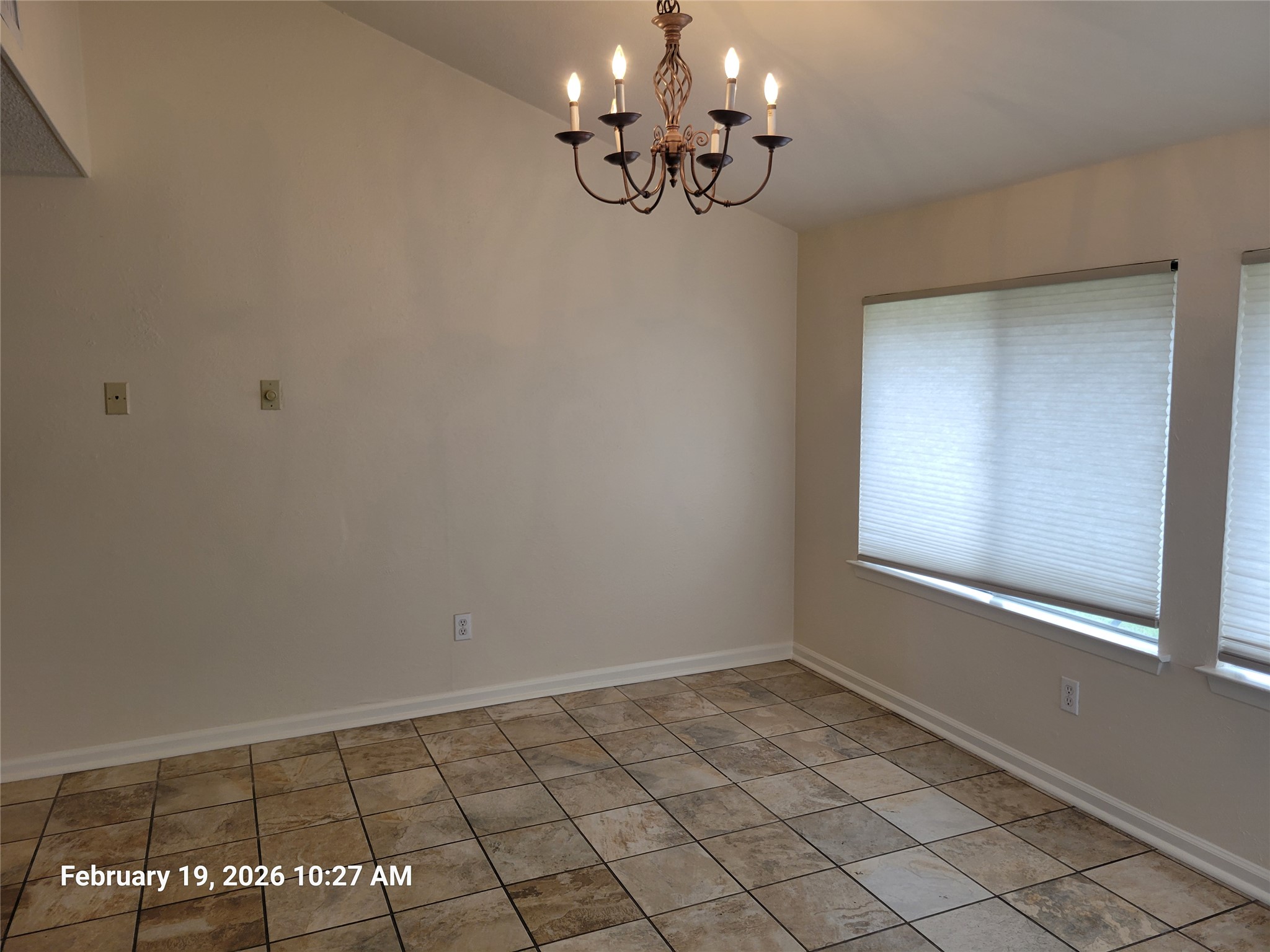 7266 Coronado Circle Austin, TX 78752 - Photo 3 of 11 Unfurnished room featuring a chandelier and vaulted ceiling