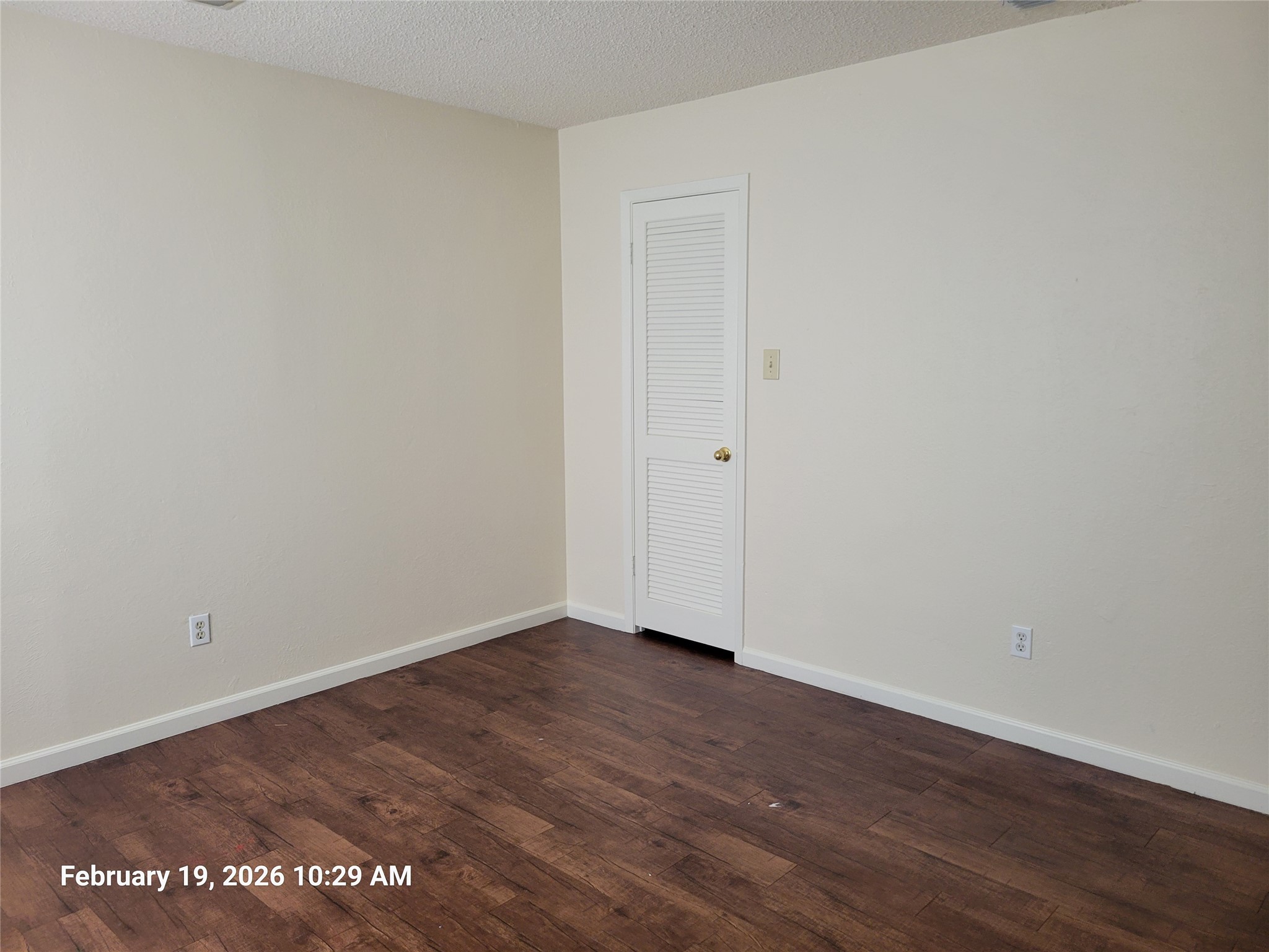 7266 Coronado Circle Austin, TX 78752 - Photo 7 of 11 Empty room with dark wood finished floors and a textured ceiling