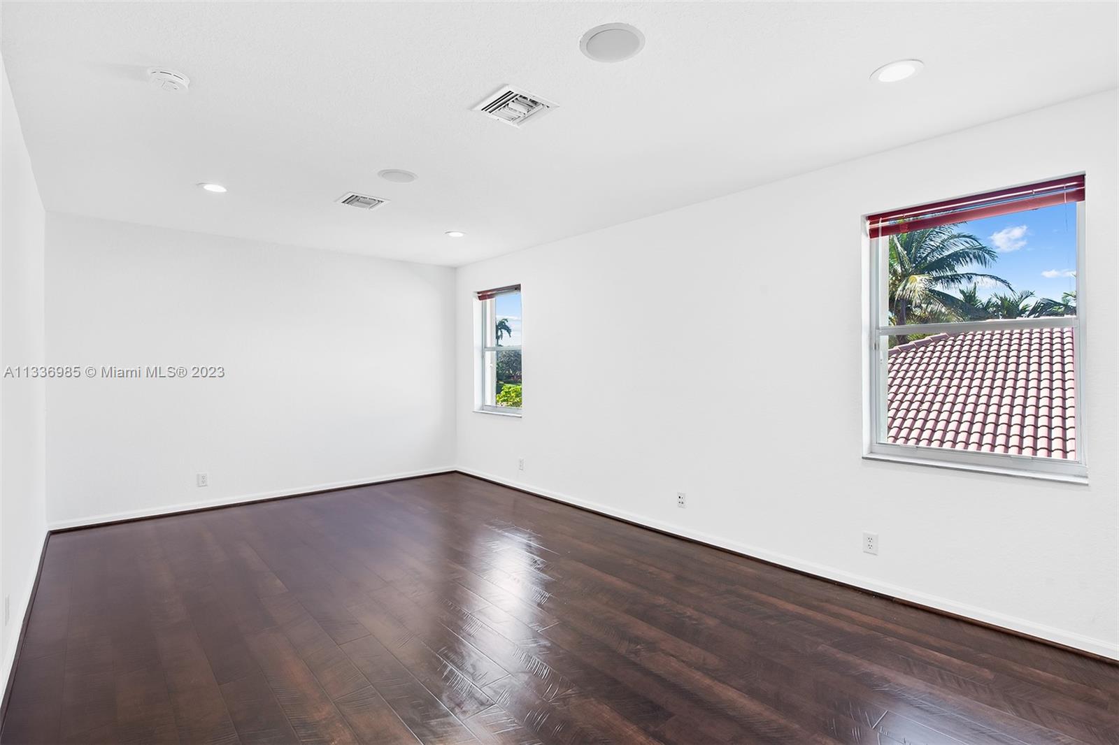 948 Windward Way Weston, FL 33327 - Photo 35 of 46 an empty room with wooden floor and windows