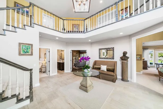 a living room with furniture stairs and a chandelier