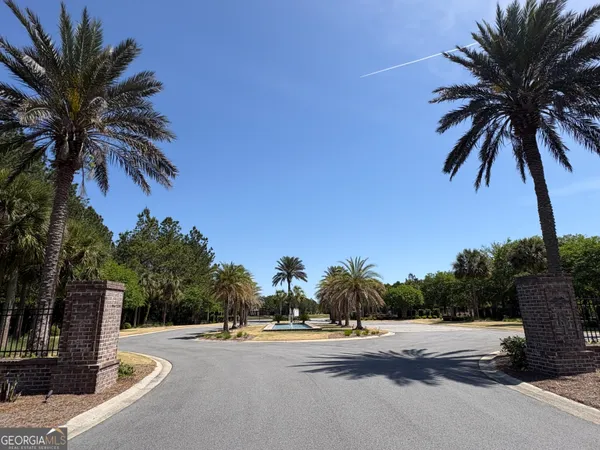 a view of a street with a building and palm trees