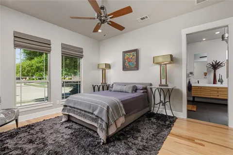 a bedroom with a bed a large window and potted plant