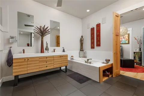 a bathroom with a double vanity sink a mirror and a bathtub