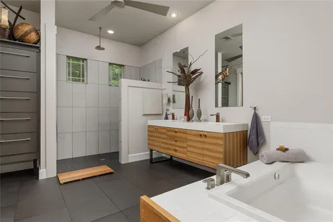 a bathroom with a double vanity sink a mirror and a bathtub