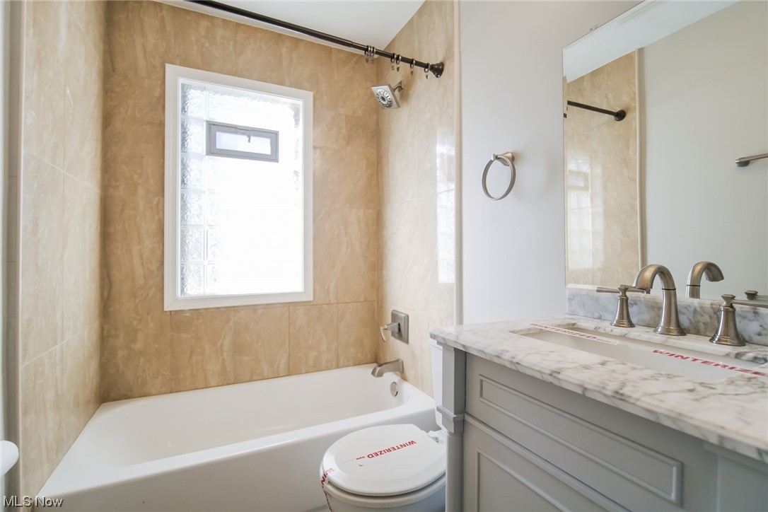 1668 Winchester Road Cleveland, OH 44124 - Photo 16 of 20 Full bathroom featuring tiled shower / bath combo, toilet, a wealth of natural light, and large vanity