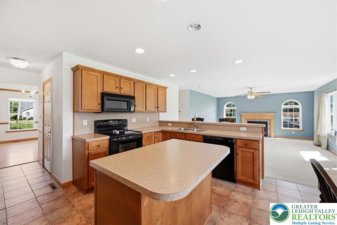 66 Labar Road Bangor, PA 18013 - Photo 10 of 56 An open-concept kitchen boasts a functional island and overlooks a spacious living area with arched windows and a fireplace.