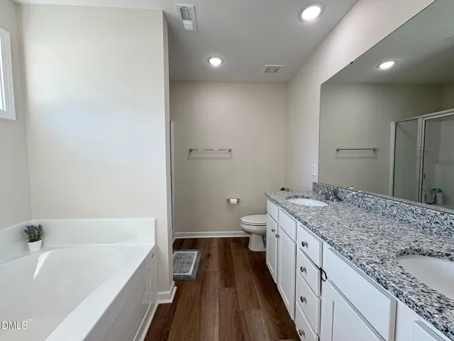 a bathroom with a granite countertop sink a toilet and bathtub