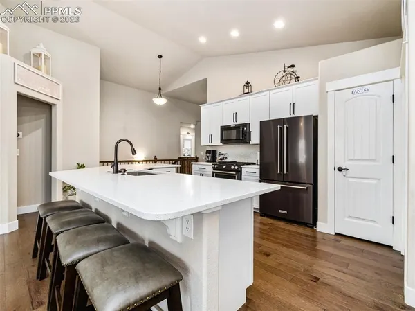 a kitchen with kitchen island a sink appliances and cabinets