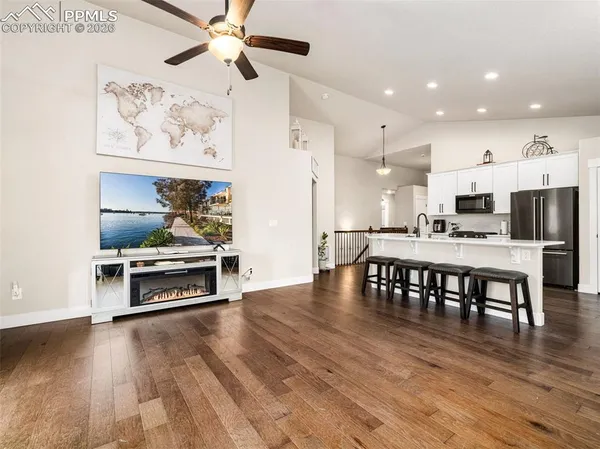 a kitchen with stainless steel appliances a dining table chairs and stove top oven