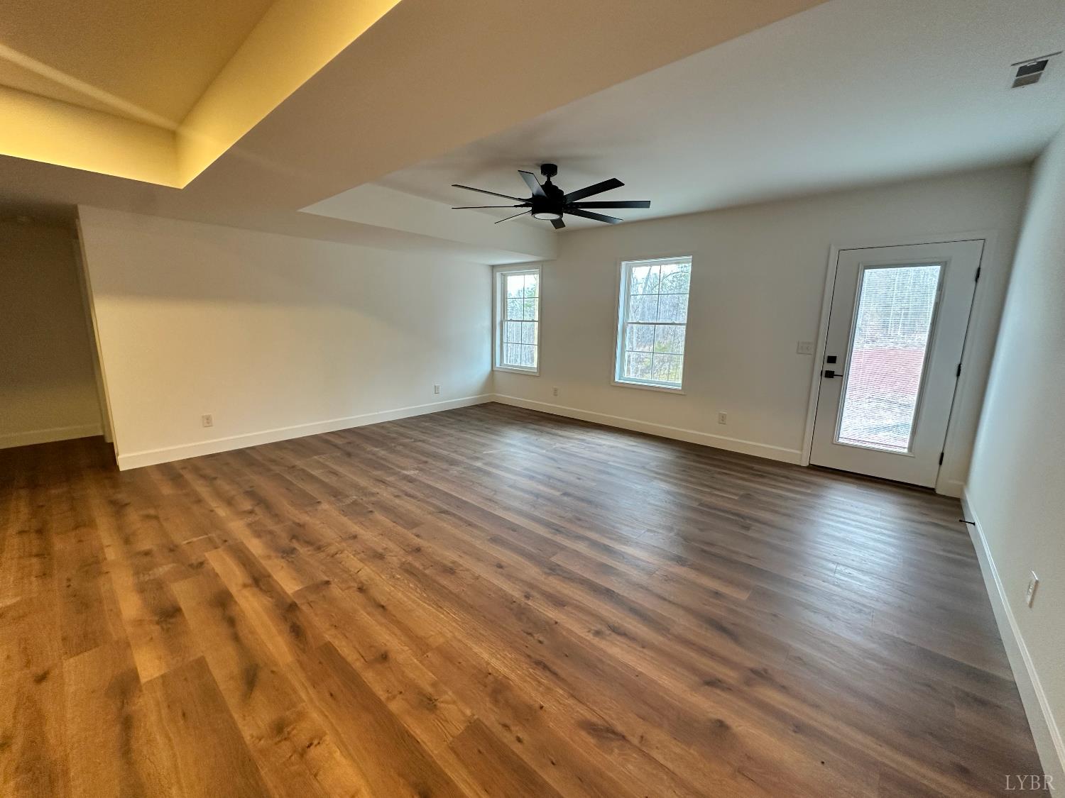 11314 Leesville Road Evington, VA 24550 - Photo 23 of 28 an empty room with wooden floor ceiling fan and windows