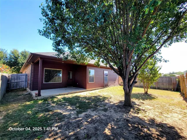 a backyard of a house with table and chairs