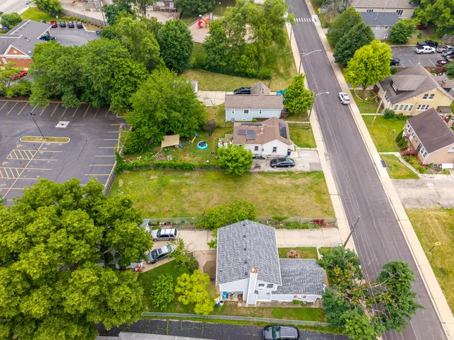 an aerial view of a house with a garden and lake view