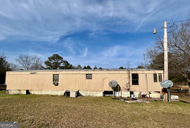 a view of a house with backyard sitting area and garden