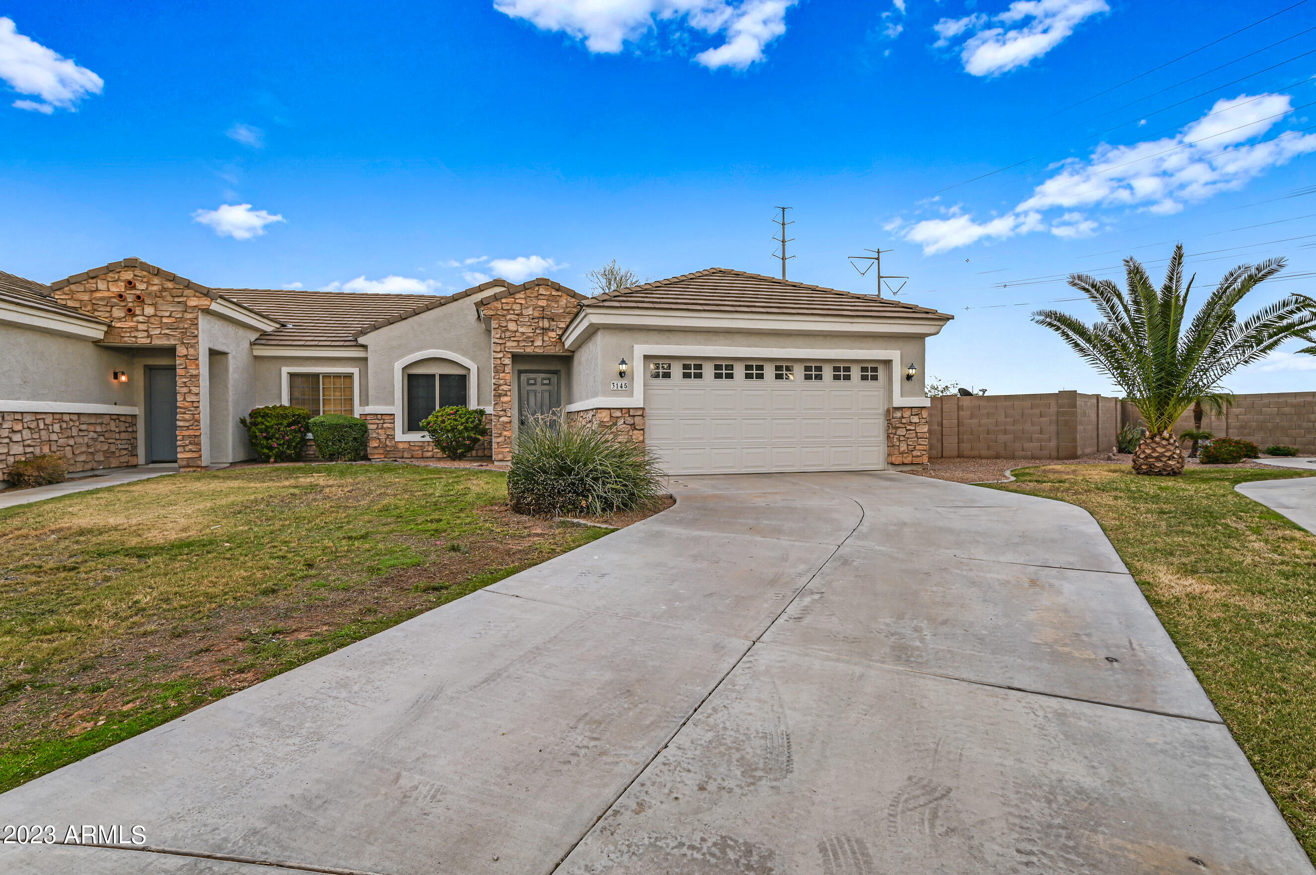 a view of a house with a yard and potted plants