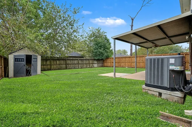 a view of a backyard with a small cabin and wooden fence