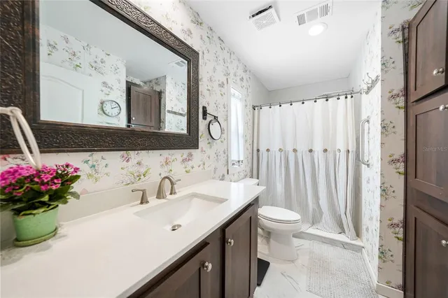a bathroom with a granite countertop sink vanity mirror and tub