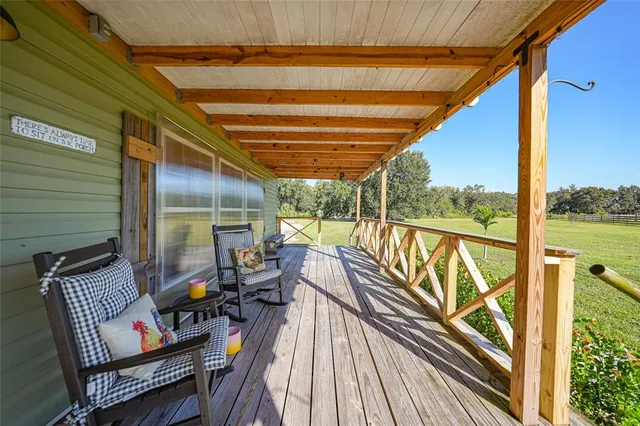 a dining room with wooden floor a chandelier a wooden table and chairs