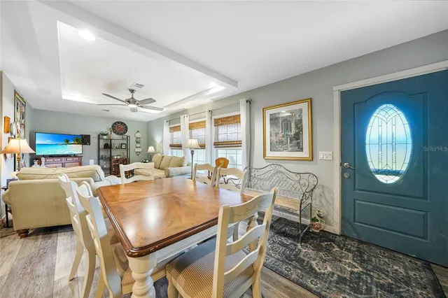 a living room with stainless steel appliances kitchen island granite countertop furniture and a wooden floor