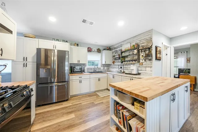 a kitchen with granite countertop a refrigerator stove and sink
