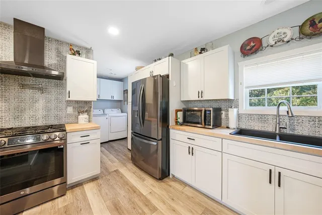 a kitchen with kitchen island granite countertop white cabinets and white appliances