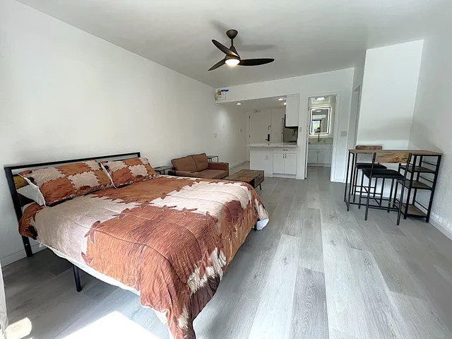a bedroom with bed and wooden floor