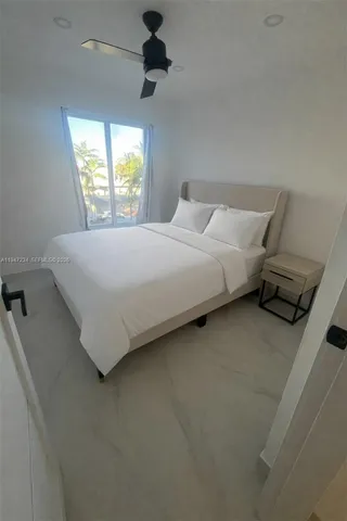 a large bed sitting in a bedroom next to a window
