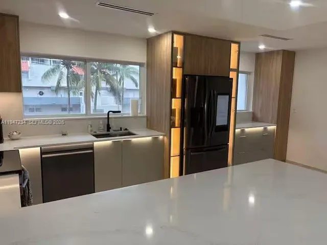 a kitchen with granite countertop a refrigerator and a sink
