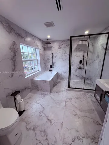 a spacious bathroom with a tub shower and mirror