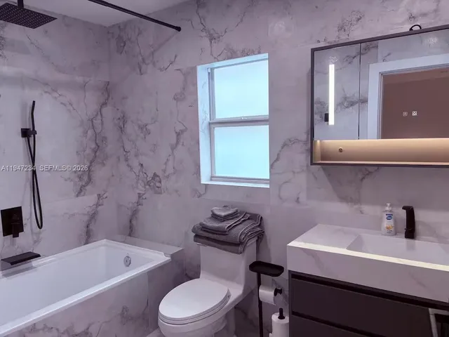 a bathroom with a sink a toilet and bathtub