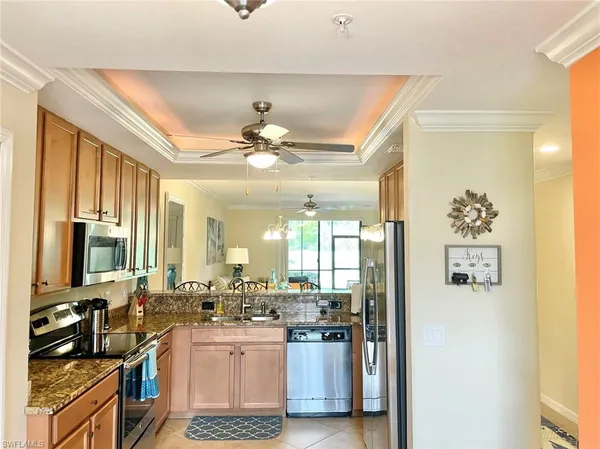 a kitchen with a sink stainless steel appliances and chandelier