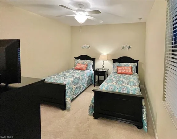 a bedroom with two beds and a flat screen tv