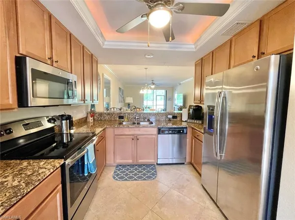 a kitchen with stainless steel appliances granite countertop a refrigerator a stove top oven a sink and dishwasher
