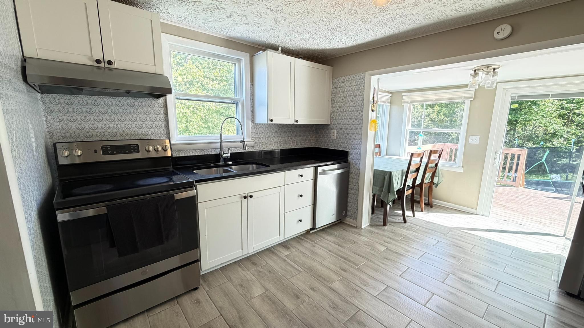 45 Figgins Road Front Royal, VA 22630 - Photo 4 of 17 a kitchen with granite countertop a stove a sink and white cabinets with wooden floor