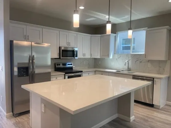 a kitchen with kitchen island a sink appliances and cabinets