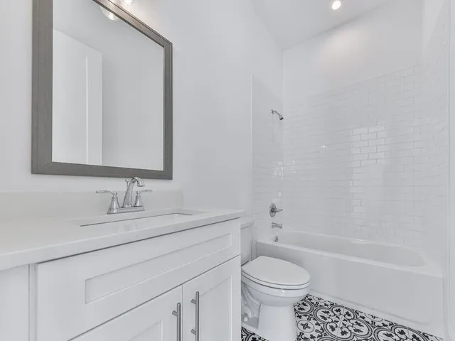 a bathroom with a sink toilet vanity and shower