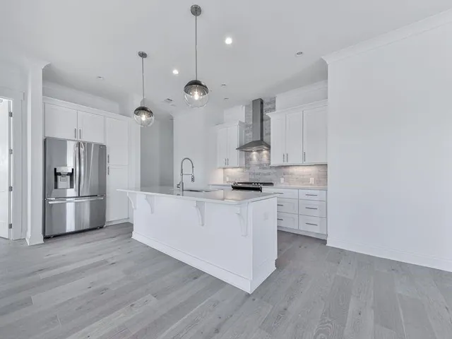 a kitchen with stainless steel appliances a sink stove refrigerator and cabinets