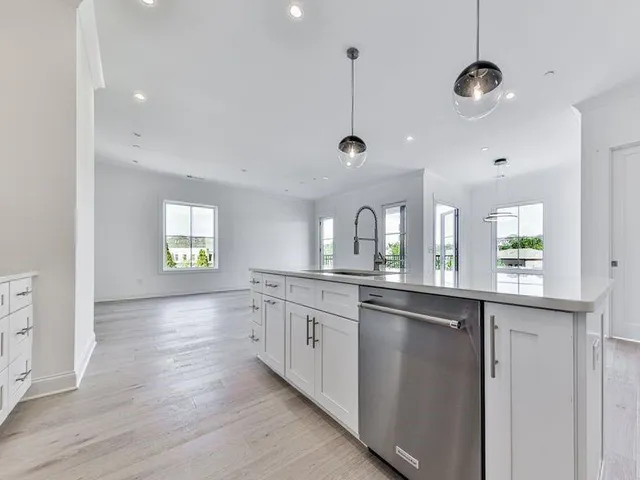 a kitchen with stainless steel appliances granite countertop a sink a stove and wooden floor